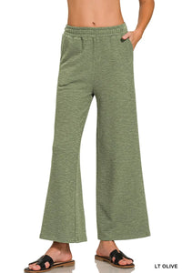Light olive green wide-leg pants worn by a person on a white background