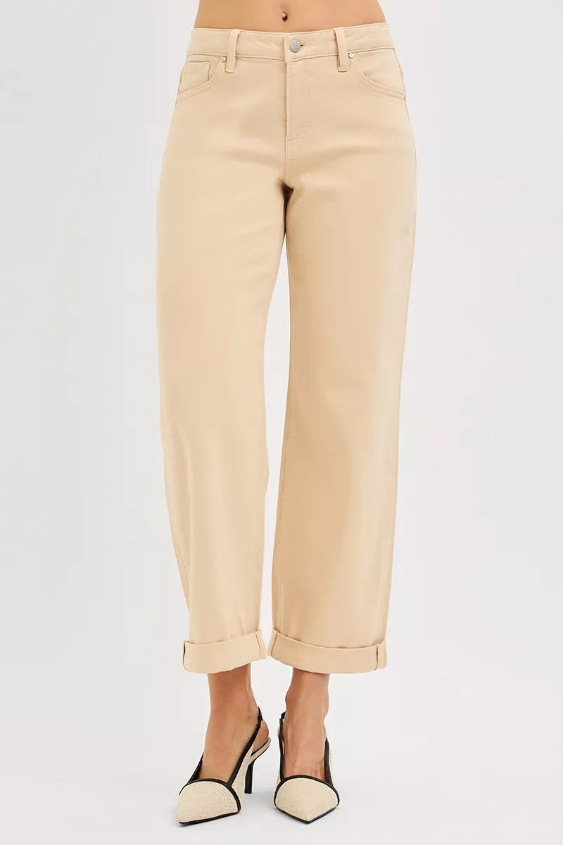 Beige jeans worn by a person on a light gray background