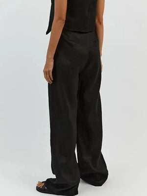 Person wearing black wide-leg pants on a white background