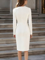 Woman wearing a white dress standing on stone steps.