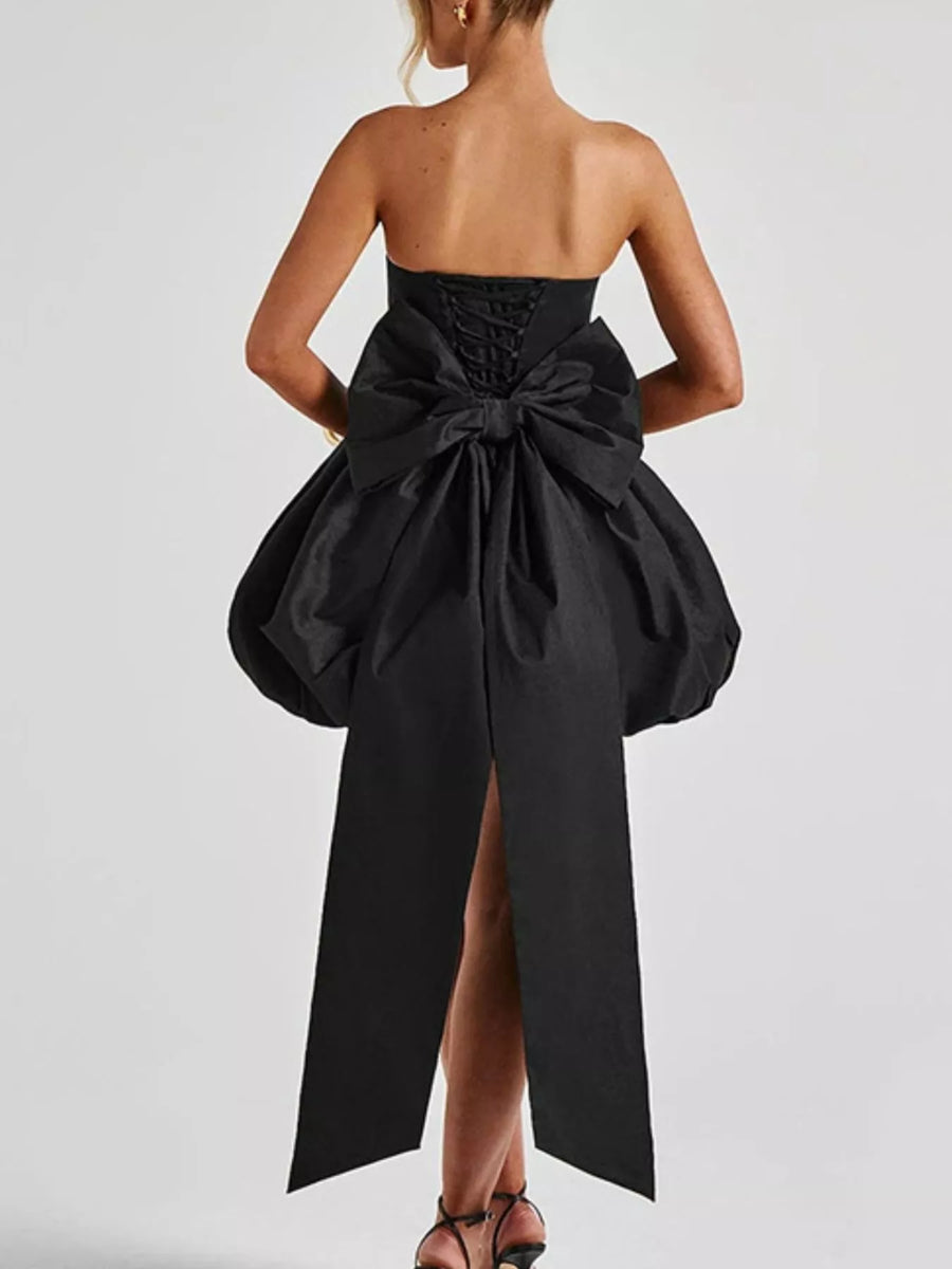 Black strapless dress with a large bow detail on a white background