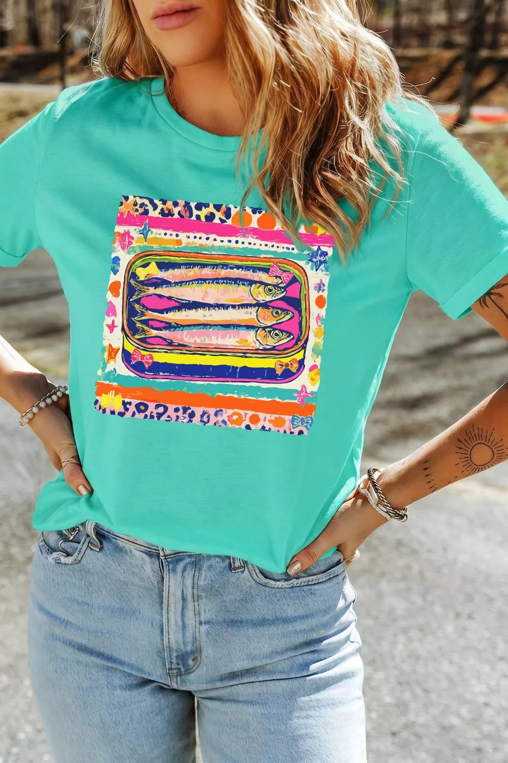 Person wearing a turquoise t-shirt with a colorful graphic design.