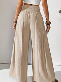 Beige wide-leg pants worn by a person on a light gray background