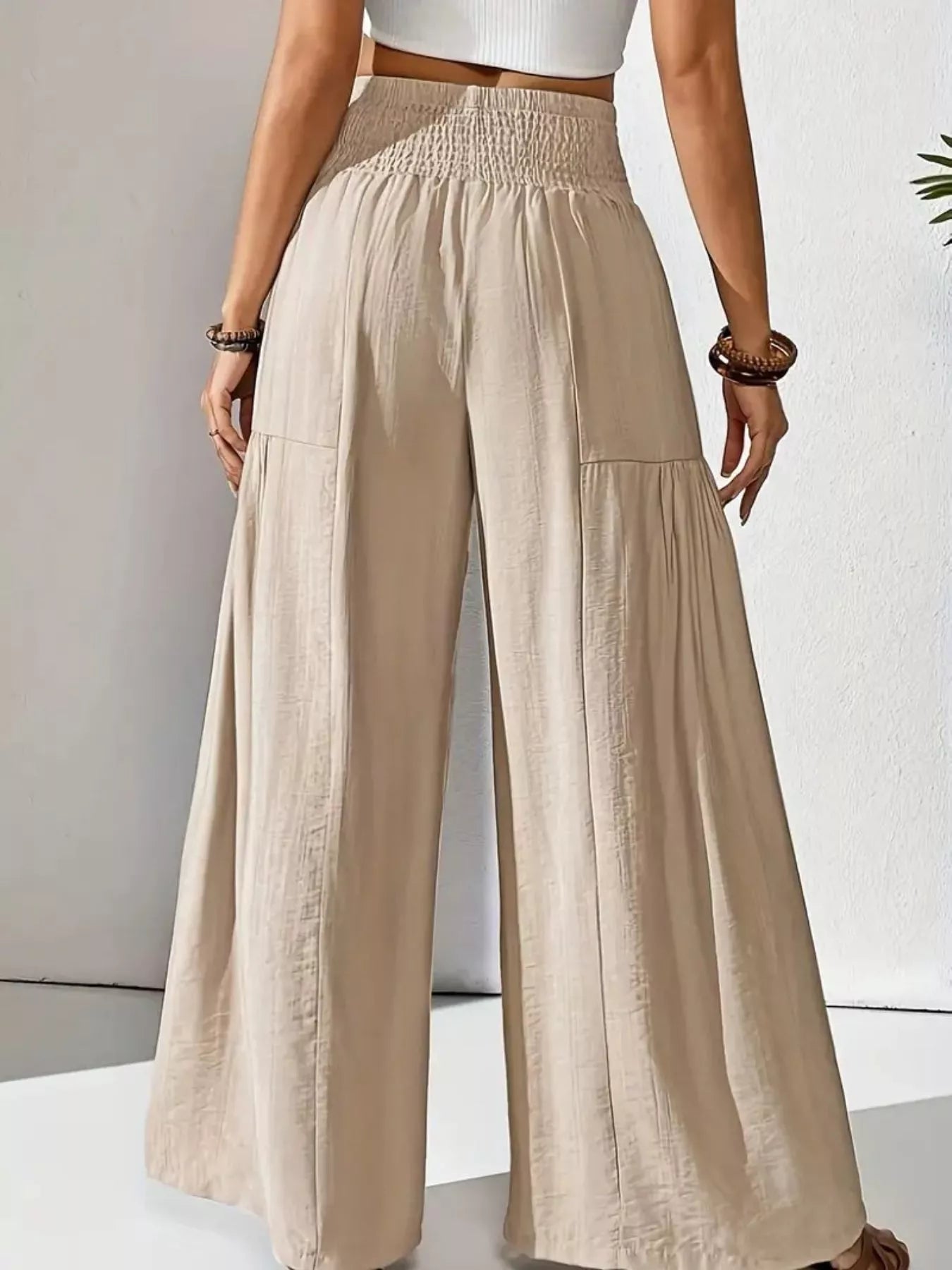 Beige wide-leg pants worn by a person on a light gray background