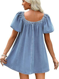 Woman wearing a light blue denim dress with puff sleeves on a white background