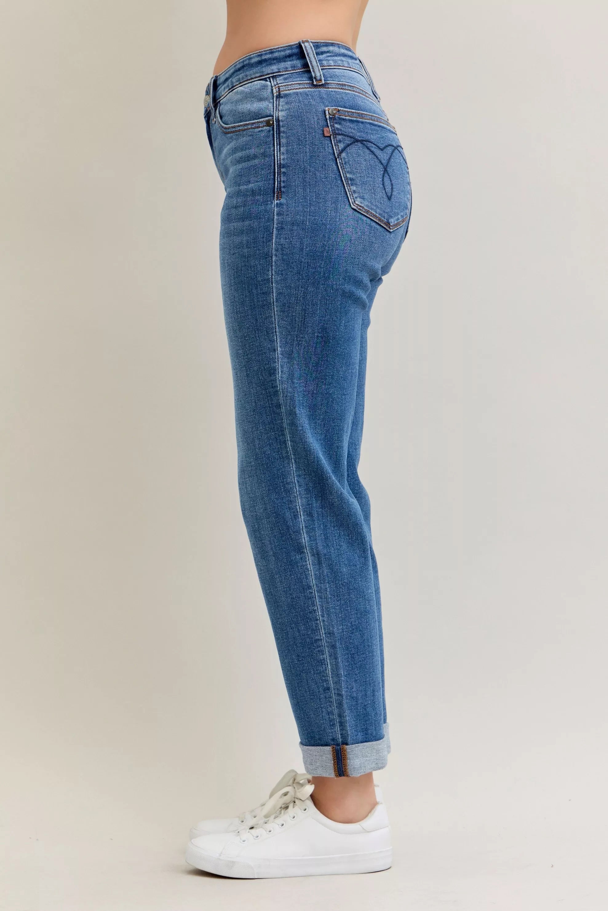Blue jeans worn by a person on a plain background