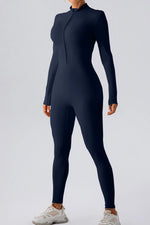 Person wearing a black full-body suit on a light gray background