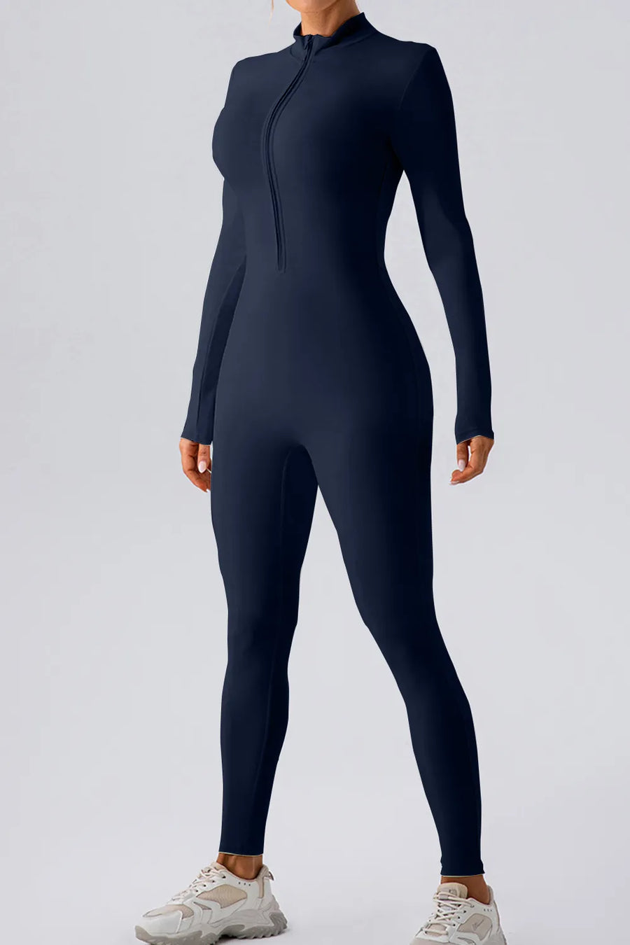 Person wearing a black full-body suit on a light gray background