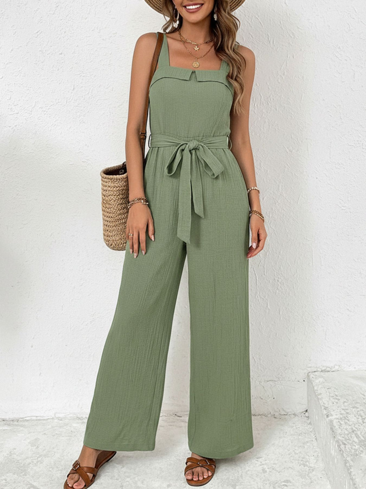 Woman wearing a green jumpsuit with a white background