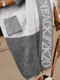 Gray sweatshirt with a logo and text on a blurred background