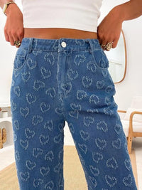 Person wearing blue jeans with a pattern, standing indoors.