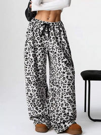 Leopard print pants worn by a person on a white background