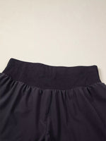 Navy blue pants with a textured waistband on a beige background
