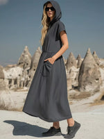Woman wearing a gray dress with hood in a desert landscape