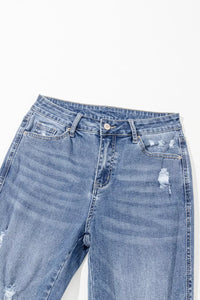 Blue jeans with slight distressing on a white background