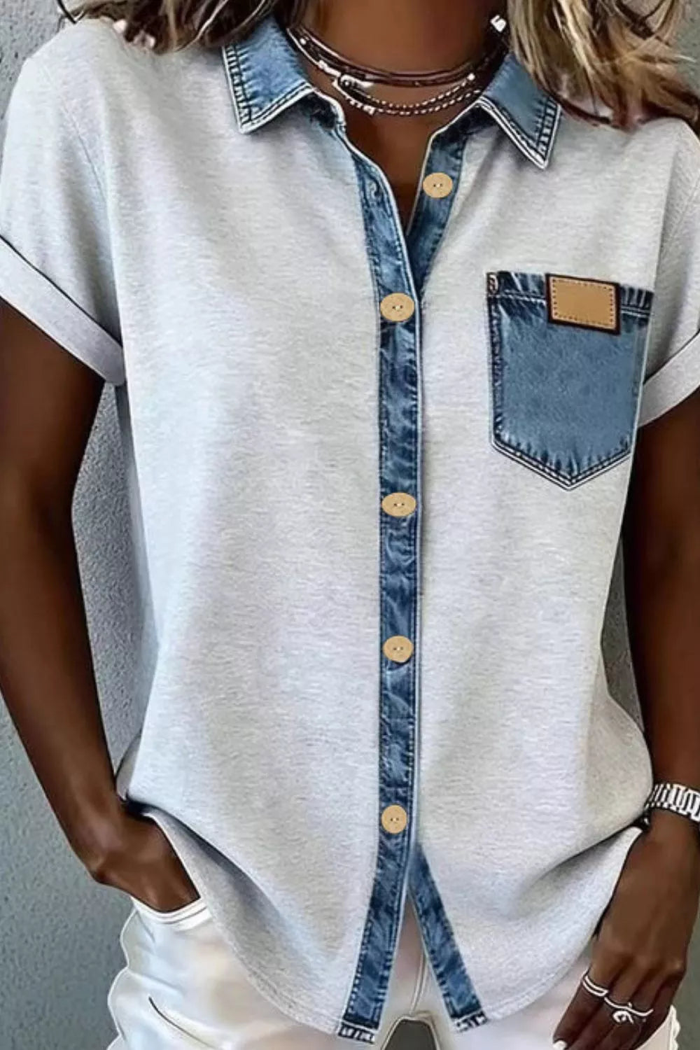 Gray shirt with denim collar and pocket worn by a person against a gray background