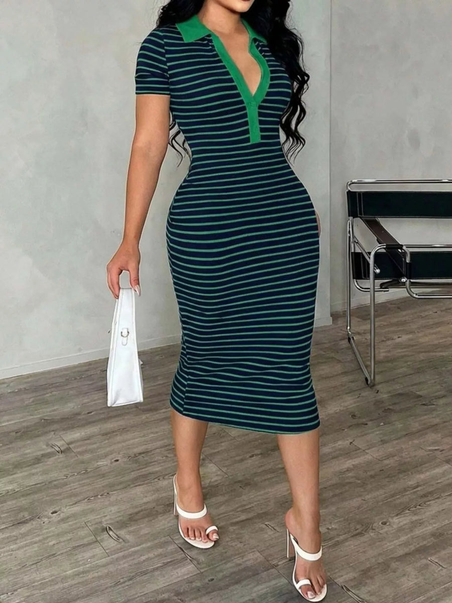 Woman wearing a green and navy striped dress with a white clutch in an indoor setting.