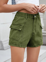 Green cargo shorts worn by a person on a light background