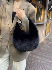 Person wearing a beige blazer with a dark fur stole outdoors.