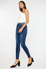 Woman wearing blue jeans and a white top on a white background