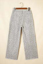 Patterned pants on a hanger against a beige background
