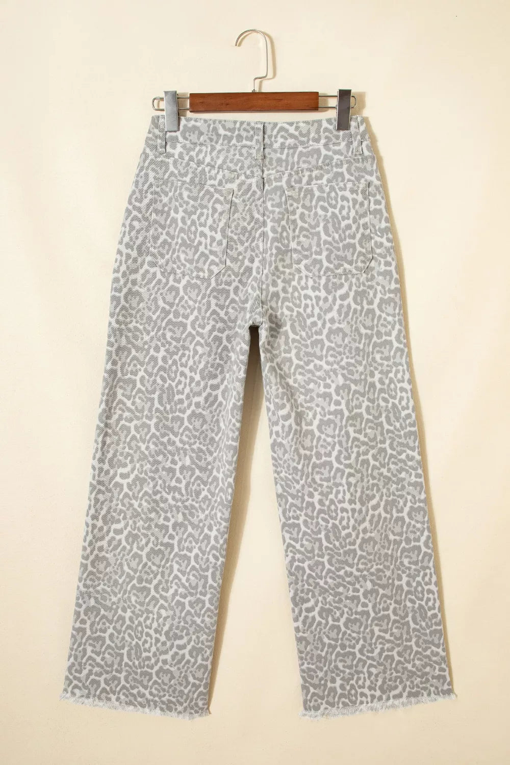 Patterned pants on a hanger against a beige background