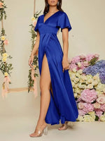Woman in a blue dress standing in front of floral decorations