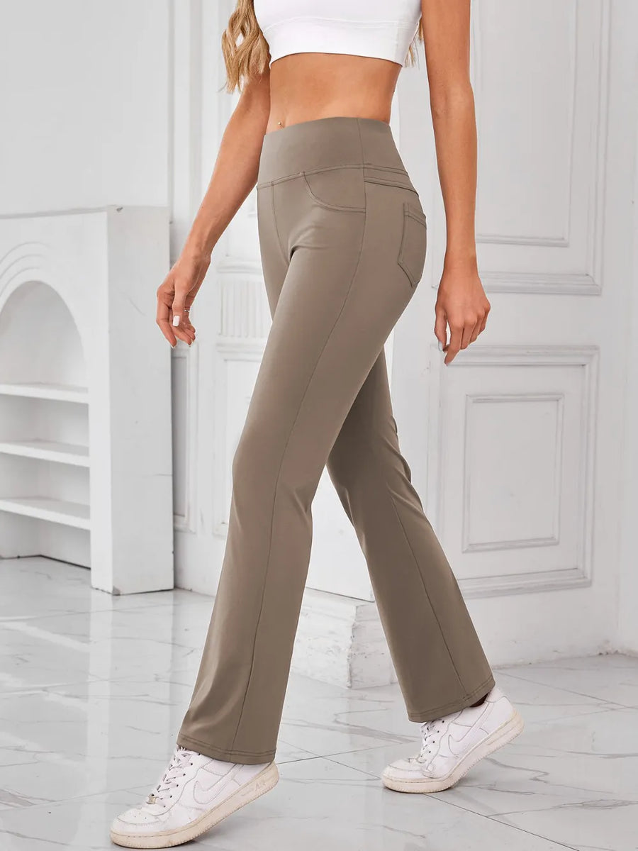 Person wearing olive green pants and white sneakers in a minimalistic setting