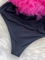 Black fabric with a pink floral arrangement on a white surface