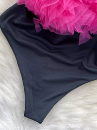 Black fabric with a pink floral arrangement on a white surface