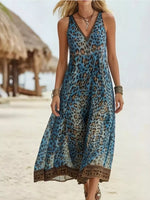 Woman wearing a blue leopard print dress on a beach.