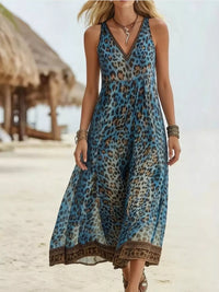 Woman wearing a blue leopard print dress on a beach.