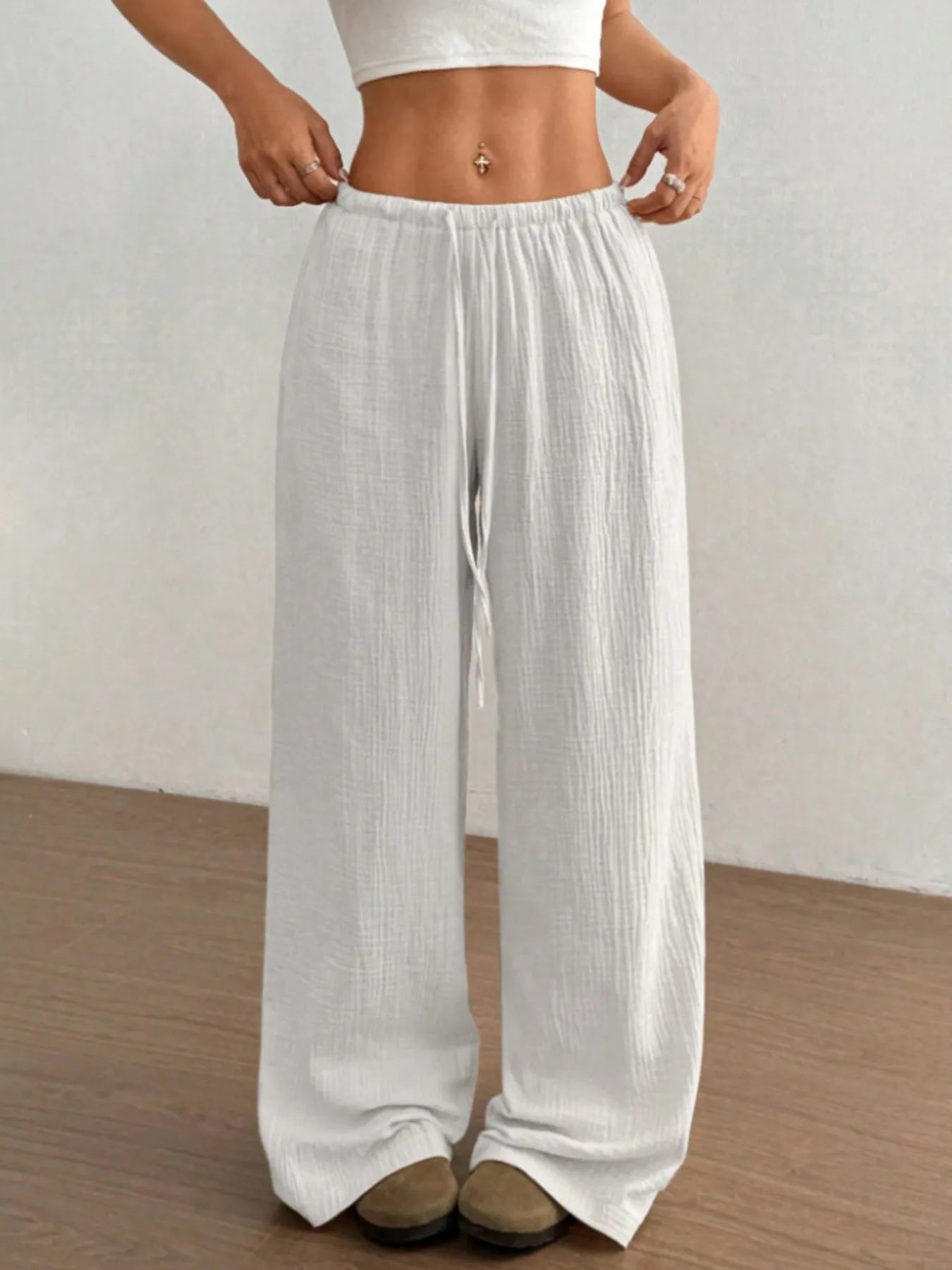 White wide-leg pants worn by a person on a plain background