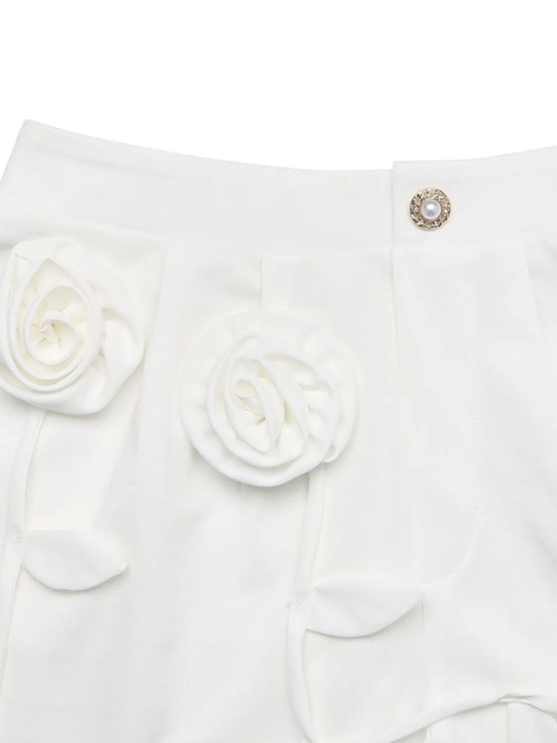 White garment with floral details and a decorative button on a white background