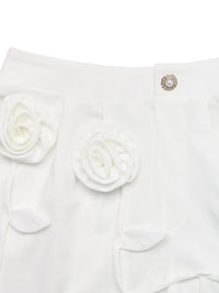 White garment with floral details and a decorative button on a white background