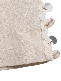 Close-up of a textured fabric surface with decorative buttons and beads on a white background