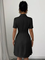 Person wearing a black dress against a white wall
