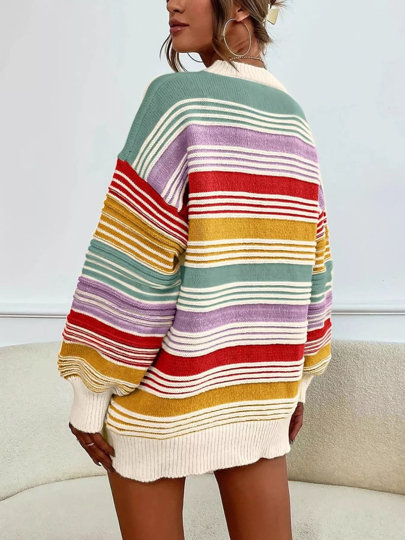 Multicolored striped sweater worn by a person on a neutral background