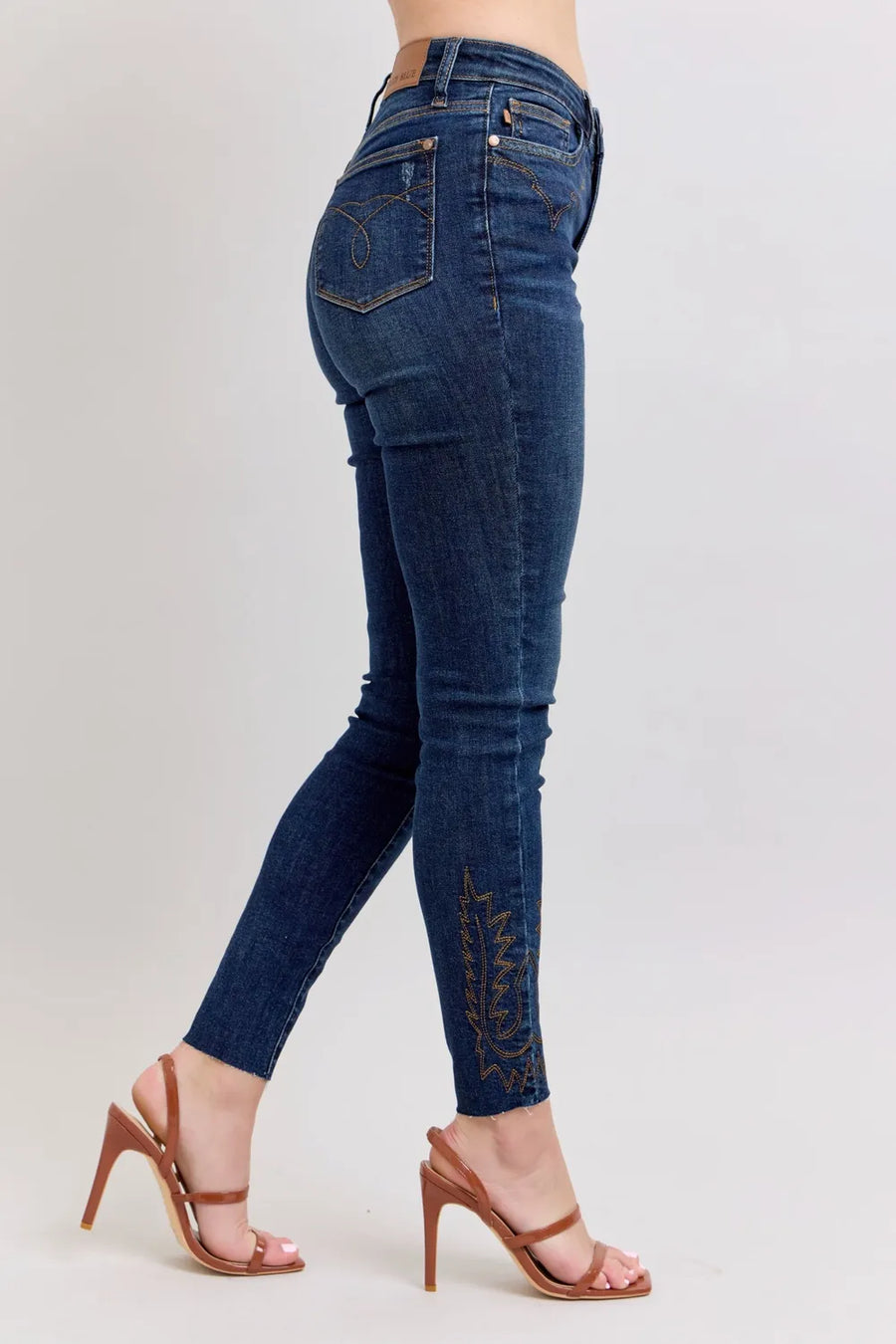 Blue jeans worn by a person on a light gray background