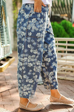 Person wearing blue floral pants with a blurred outdoor background