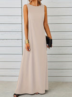 Woman wearing a beige sleeveless dress against a wooden background
