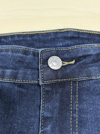 Close-up of a blue denim button on a beige background