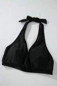 Black bikini top with halter neck and bow detail on a light gray background