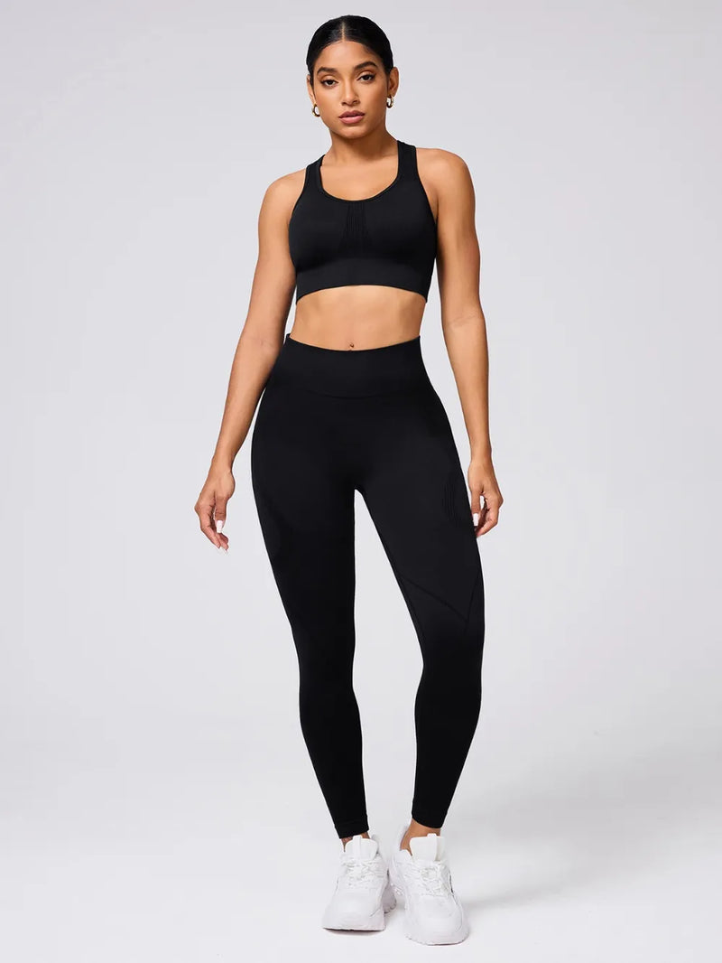 Woman wearing a black sports bra and leggings set on a white background