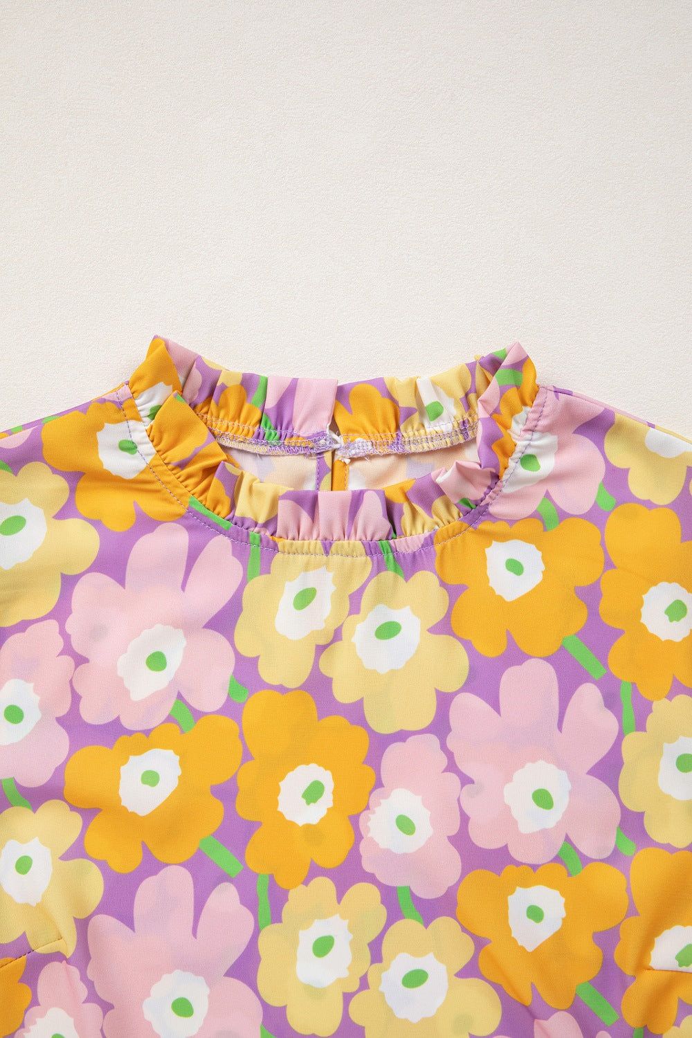 Floral patterned fabric with orange, pink, and purple flowers on a white background