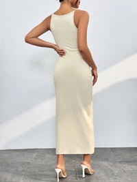 Woman wearing a beige sleeveless dress against a plain background