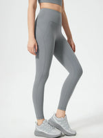Person wearing gray leggings and sneakers on a white background
