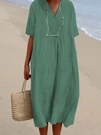 Person wearing a green dress on a beach