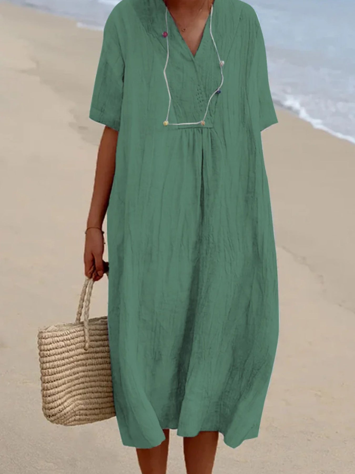 Person wearing a green dress on a beach