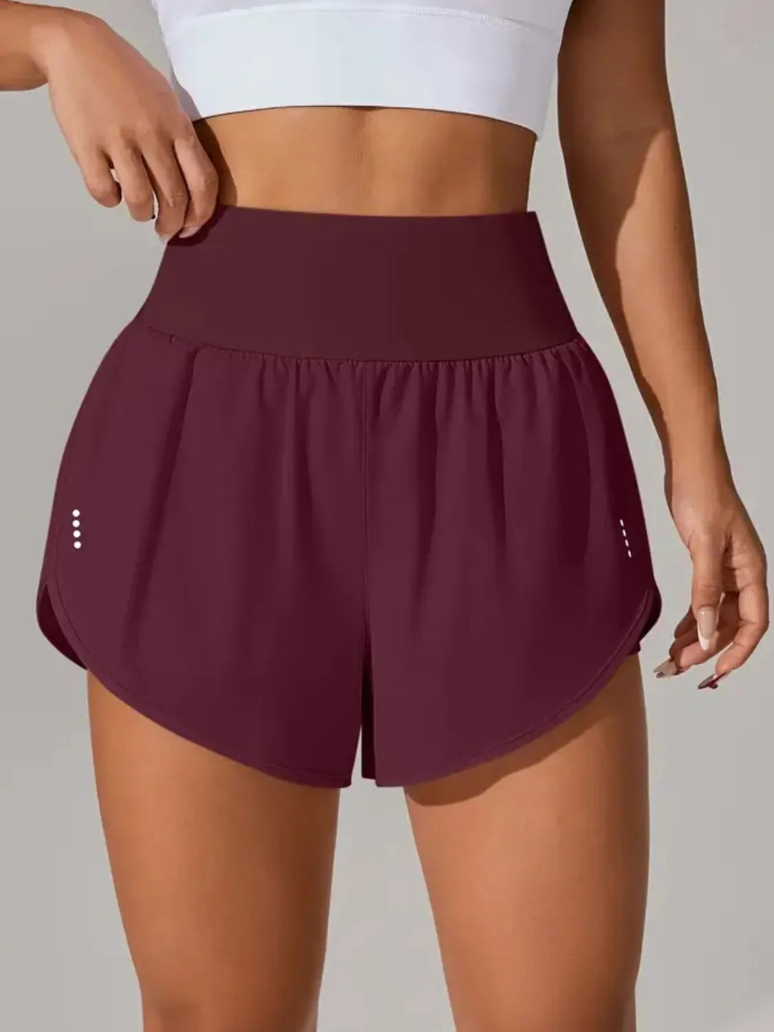 Maroon athletic shorts worn by a person on a neutral background